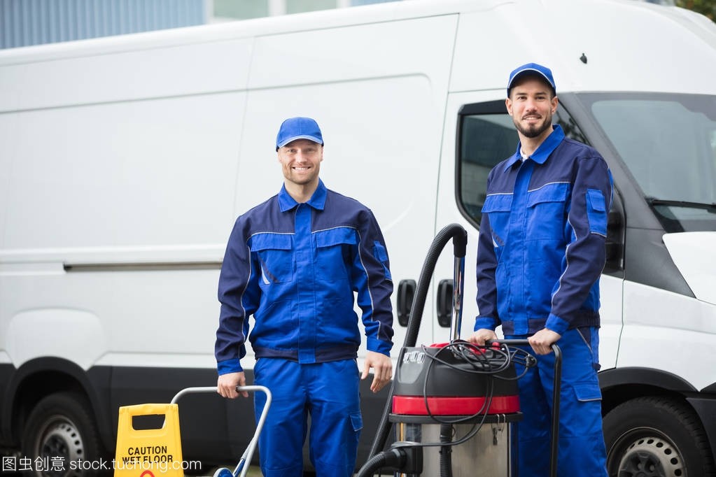 兩個快樂男清潔工的肖像站在清潔設(shè)備